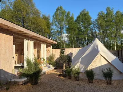 a white tent in a yard next to a building at Wellness B&B Essential by Cin in Zonhoven