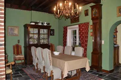 a dining room with a table and white chairs at Hof ter Wallen in Zoutleeuw