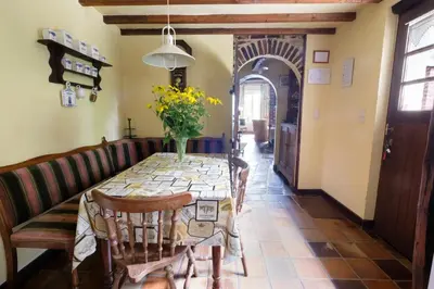 a dining room table with a vase of flowers on it at Hof ter Wallen in Zoutleeuw