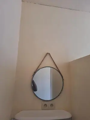 a mirror hanging above a toilet in a bathroom at Tc home in Liège