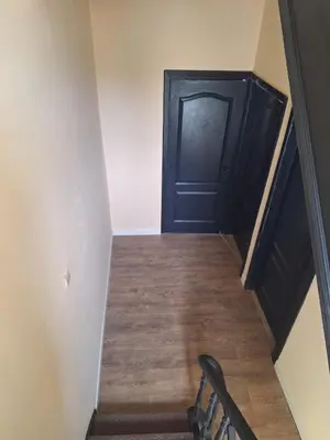 a hallway with a black door and a wooden floor at Tc home in Liège