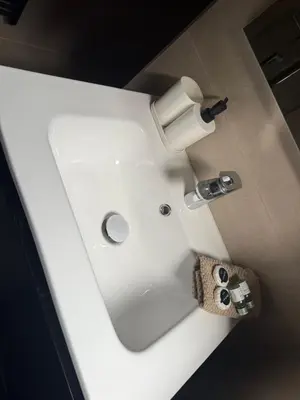 a white bathroom sink with a roll of toilet paper at Luxury Riverfront Apartment near La Meuse in Liège