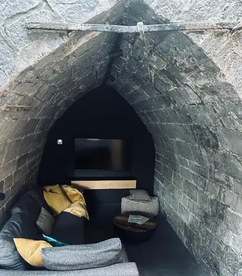 a brick tunnel with a couch and a tv at La Tour in Liège