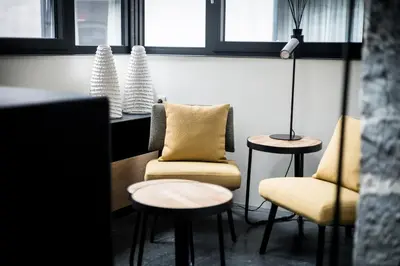 a room with two chairs and a lamp and windows at La Tour in Liège