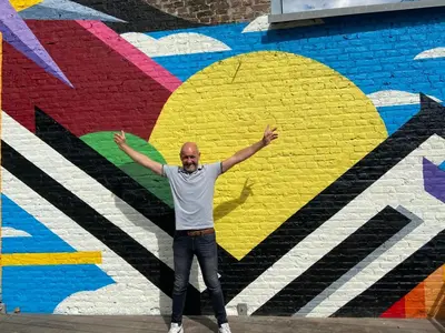 a man standing in front of a mural at La Tour in Liège