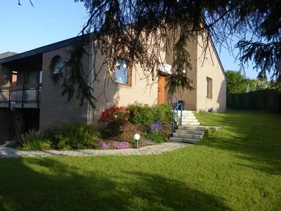 a house with a tree in front of a yard at Aux Cosmos in Olne