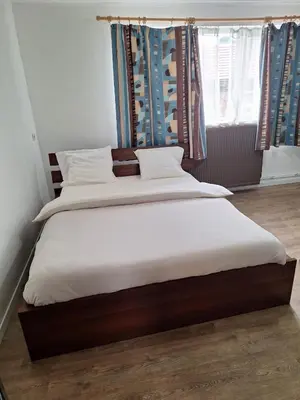 a bedroom with two beds with white sheets and a window at Maison sympathique in Liège