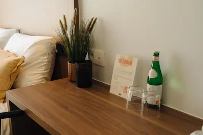 a bottle of wine on a table next to a bed at Door9 Hasselt - Digital Hotel & Restaurant in Hasselt