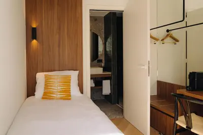 a bedroom with a bed and a bathroom at Door9 Hasselt - Digital Hotel & Restaurant in Hasselt