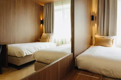a hotel room with two beds and a mirror at Door9 Hasselt - Digital Hotel & Restaurant in Hasselt