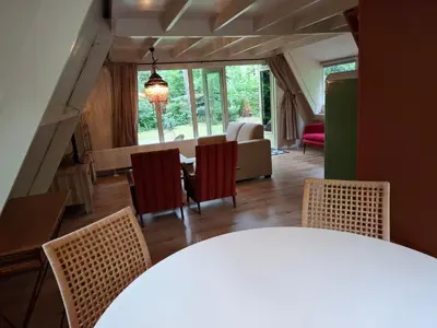 a living room with a table and chairs at Bosrijk gelegen vakantiehuis met optimale privacy! in Lanaken