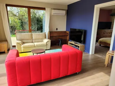 a living room with a red couch and a tv at Casa Loon in Borgloon