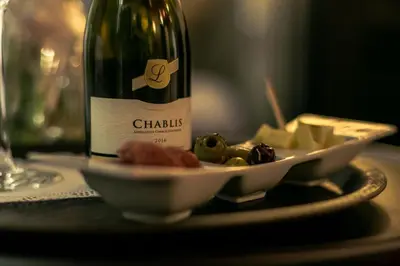 a bottle of wine sitting next to a plate of food at Le Vénitien in Liège