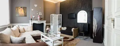 a living room with a white couch and a fireplace at Le Vénitien in Liège