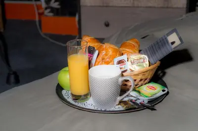a plate with a basket of bread and a glass of orange juice at Le Vénitien in Liège