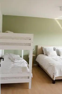 a bedroom with two bunk beds and a bed at Vakantiewoning Ten Huyze Bucholt met tuinsauna in Bocholt