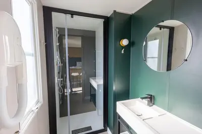 a bathroom with a shower and a sink and a mirror at Family chalet Kinrooi - Papillon Kinrooi in Kinrooi