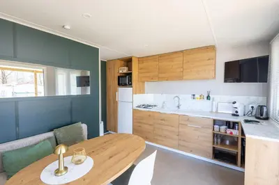 a kitchen with a wooden table and a dining room at Family chalet Kinrooi - Papillon Kinrooi in Kinrooi