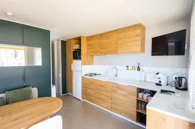 a kitchen with wooden cabinets and a counter top at Family chalet Kinrooi - Papillon Kinrooi in Kinrooi