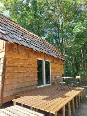 a log cabin with a bench on a deck at Mirabel - DreamsCanGrow in Hasselt