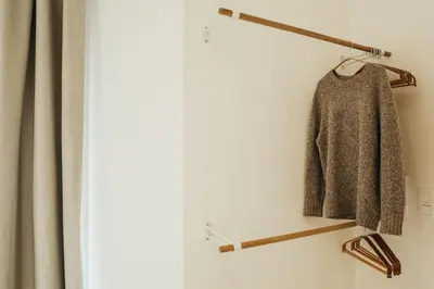 a sweater hanging on a coat rack next to a window at Beauvoir, Parc de la Boverie by WelcHome in Liège