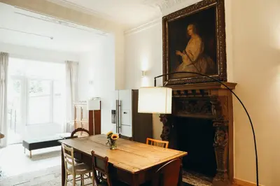 a dining room with a table and a painting on the wall at Beauvoir, Parc de la Boverie by WelcHome in Liège