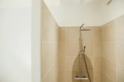 a bathroom with a shower with a shower curtain at Beauvoir, Parc de la Boverie by WelcHome in Liège