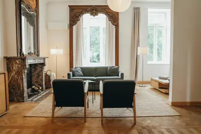 a living room with a couch and a table and chairs at Champagne, Parc de la Boverie by WelcHome in Liège