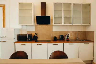 a kitchen with white cabinets and wooden counter tops at Champagne, Parc de la Boverie by WelcHome in Liège