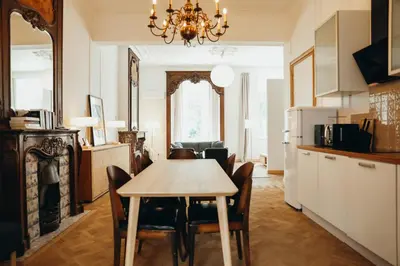 a kitchen and dining room with a table and chairs at Champagne, Parc de la Boverie by WelcHome in Liège