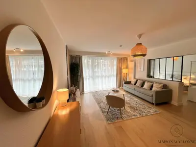 a living room with a couch and a mirror at Open Design apartment in Liège