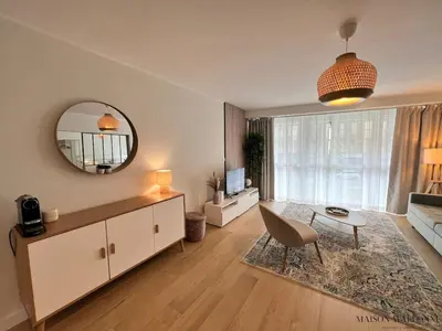 a living room with a table and a mirror at Open Design apartment in Liège
