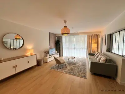 a living room with a couch and a table at Open Design apartment in Liège