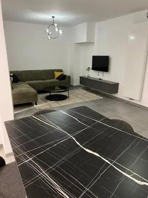 a living room with a couch and a television at Heel Appartement 90m2 met 2 slaapkamers woonkamer Keuken badkamer privé garage in Sint-Truiden