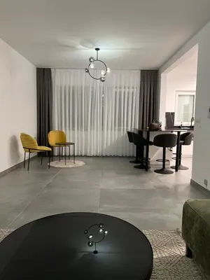 a living room with a table and a piano at Heel Appartement 90m2 met 2 slaapkamers woonkamer Keuken badkamer privé garage in Sint-Truiden