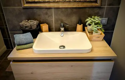 a bathroom with a white sink on a wooden counter at Landbæne in Lommel