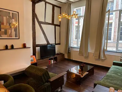 a living room with a couch and a tv at Le cocon chic - Hypercentre, Place du Marché in Liège