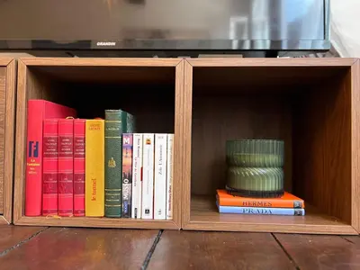 a wooden book shelf filled with books and a stack thereof at Le cocon chic - Hypercentre, Place du Marché in Liège