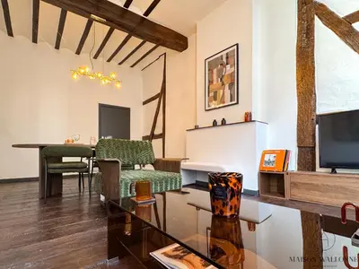 a living room with a table and a tv at Le cocon chic - Hypercentre, Place du Marché in Liège