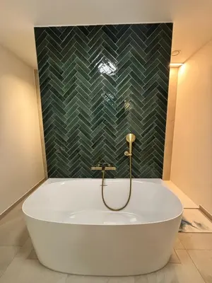 a bath tub in a bathroom with a green wall at Home Terboekt in Genk