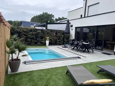 a swimming pool in a backyard with chairs and a table at Home Terboekt in Genk