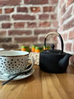 a tea kettle and a cup on a table at Les Tours de Rose - Characterful accommodation in Waremme in Waremme