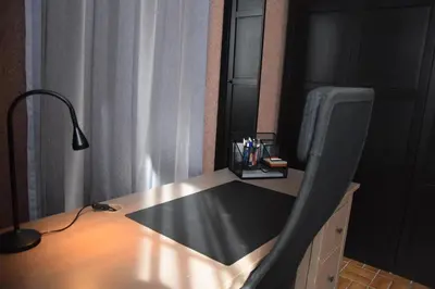 a desk with a chair next to a desk with a lamp at La Belle Échappée à Fléron in Fléron