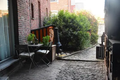 a patio with a table and chairs on a street at La Belle Échappée à Fléron in Fléron