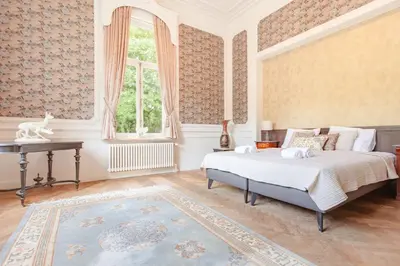 a bedroom with a bed and a desk and a window at 12P 6B Renovated villa with jacuzzi at Genk in Genk