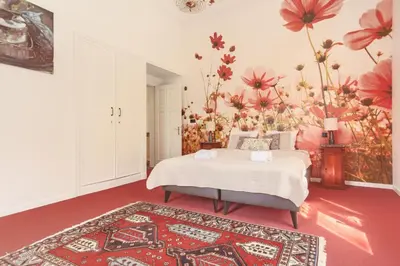 a bedroom with a bed and a floral wall at 12P 6B Renovated villa with jacuzzi at Genk in Genk