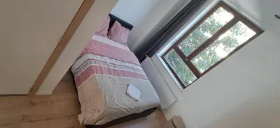 a bedroom with a bed and a window at Appartement dans rue calme in Liège