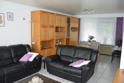 a living room with a leather couch and a table at Charming Belgian Getaway, vakantiewoning in Oudsbergen - 3 Bedrooms Garden in Oudsbergen
