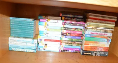 a stack of books sitting on a shelf at Charming Belgian Getaway, vakantiewoning in Oudsbergen - 3 Bedrooms Garden in Oudsbergen