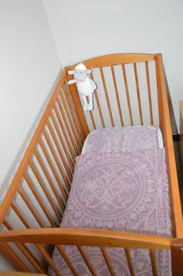 a wooden crib with a purple blanket on it at Charming Belgian Getaway, vakantiewoning in Oudsbergen - 3 Bedrooms Garden in Oudsbergen